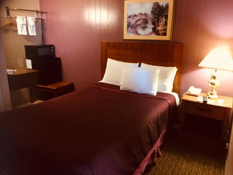 Guest room with queen bed, microwave and refrigerator
